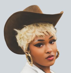 Ashley "LayLay" Staples, professional natural hair stylist and loctitian at Nappy Hutt LLC, in a professional headshot.