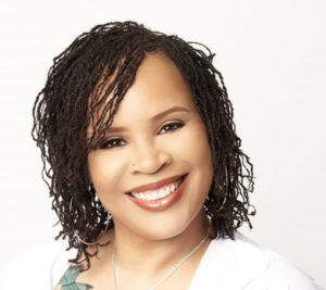 Shawntel M. Waajid, founder of Nappy Hutt LLC and natural hair expert, smiling in a professional headshot.